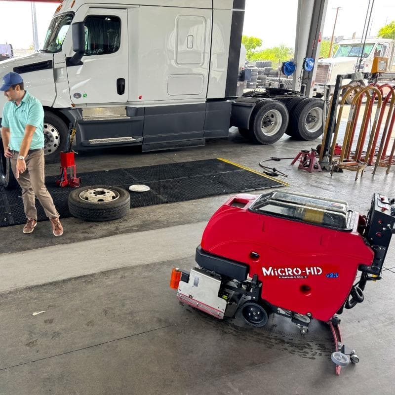 FactoryCat Walk Behind Floor Scrubbers Micro-HD service bay concrete - https://assets.factorycat.com/demoImages/2025/april/Micro-HD-Walk Behind Floor Scrubbers-service bay-concrete-Pheonix-USA-432.jpg - 800 - 800 - 432 A FactoryCat Micro-HD battery floor scrubber cleaning the concrete floor of a tire shop service bay in Phoenix, AZ